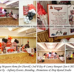 A full view of Charvik's "Two Fast" Lightning McQueen party. The setup includes a character-themed cake table, a milestone book, and a red, black, and white balloon garland.