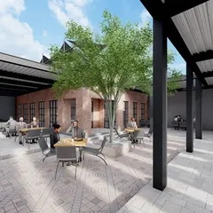 A wider view of the cafe's central courtyard, designed to be a social hub. The layout provides a mix of open and covered seating, centered around a mature tree to offer natural shade and a sense of tranquility.