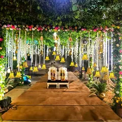 A wedding mandap should feel like a sacred garden, and for this nighttime ceremony, I created just that. The structure is enveloped in lush natural greenery and floral arrangements, with dozens of hanging bells and flowers illuminated to create a truly magical and romantic setting.