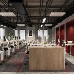 The open-plan workstation area at Mahalakshmi Logistics, featuring an industrial design with exposed ceilings and ducting. We incorporated dedicated privacy pods with red acoustic paneling for quiet work or calls.