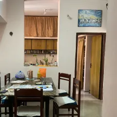 The "before" shot of a 3BHK residence in Indiranagar, showing the original closed-off kitchen and dining area. This serves as the starting point for the complete renovation project.