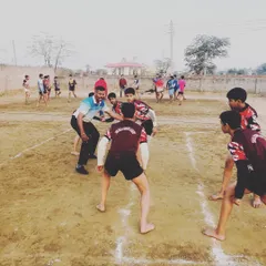 Leading by example. I am demonstrating a defensive stance to our junior players during a practice match on the mud court.