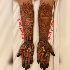 A classic bridal design featuring portraits of the groom and bride on the palms. The arms are decorated with elephants and a Sanskrit blessing, "Akhand Saubhagyavati Bhava," wishing the bride eternal marital bliss.