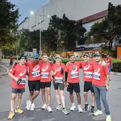 A group of our runners posing together after a training session. The matching red ASICS t-shirts create a strong sense of team identity.