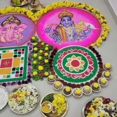 A colorful floor arrangement for a Gruhapravesh pooja, featuring rangolis of Lord Ganesha and Lord Vishnu. This setup is designed to bring blessings of prosperity and remove obstacles for the family entering their new home.