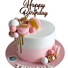 This modern and chic birthday cake features a clean white and pink finish with a stylish gold drip. I decorated it with pink and gold chocolate spheres and matching macarons.