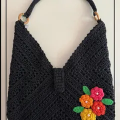 My black beauty bag is a true showstopper. The intricate crochet work is highlighted with bright, handmade flowers, creating a unique piece that will grab everyone’s attention.