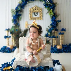 This little Krishna is sitting regally on his throne, ready to rule Vrindavan. The royal blue and gold setup is perfect for a festive feel.