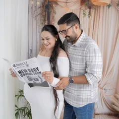 Let's have some fun with your announcement! This couple shared a laugh over a custom "New Baby Coming Soon" newspaper in our cozy boho-themed studio setup. These playful moments create such warm, authentic memories.