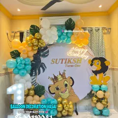 A Lion King theme for Sutiksh's first birthday. This royal setup features a Simba backdrop, a marquee number '1', and a balloon garland in teal, orange, and gold.