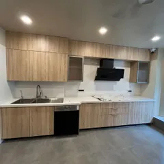 A straight-line kitchen with a timeless wooden finish. This design brings a touch of nature indoors and features integrated appliances, including a dishwasher, for a clean and functional space.