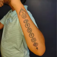 This forearm piece depicts the seven chakras aligned vertically, topped with a Trishul. It's a beautiful representation of spiritual energy and balance.