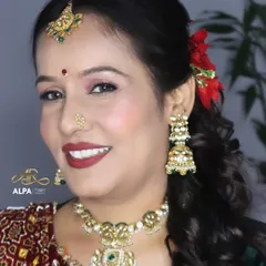 A happy client in her 40s, ready for a wedding function. I gave her a classic look with a bold red lip, soft shimmery eyes, and traditional jewelry.