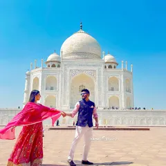 Leading the way to a new life together, with the Taj Mahal as your witness. The vibrant colors of the attire pop against the pristine white marble, creating a visually stunning photograph.