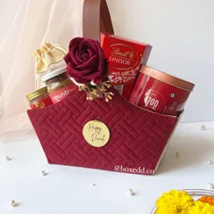 This is one of my signature Diwali hampers. I love combining rich textures and a festive color palette, like this quilted maroon basket, filled with gourmet treats and luxury items to make the celebration feel extra special.