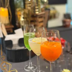 A colorful trio of our signature drinks. From a vibrant green cooler to a zesty orange juice, each drink is made with fresh ingredients to impress your guests.