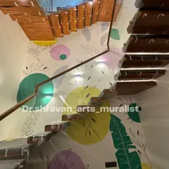 A triple-height wall transformed with a boho theme. The playful mix of colorful circles and delicate leaf outlines enhances the minimalist feel of this modern staircase.