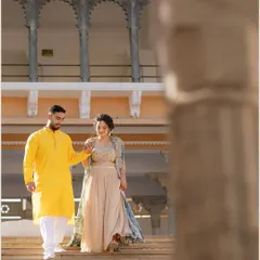 The couple walks hand-in-hand down the steps of a palace, framed by an archway. This shot captures a natural, in-between moment with a beautiful architectural element.