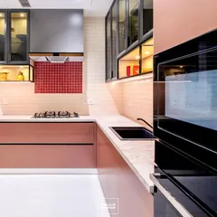 This angle highlights the kitchen's practical layout, with the built-in oven at a convenient height and ample counter space next to the hob. The under-cabinet lighting illuminates the workspace perfectly.
