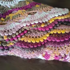 This folded view of the Virus Shawl highlights the rich texture and layers of color. The combination of pinks, yellows, and browns in this yarn is just gorgeous.