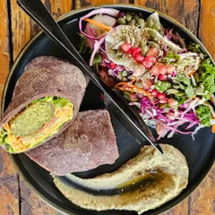 A delicious and healthy meal from a trip to Goa. This is a ragi wrap filled with fresh ingredients, served with a vibrant salad and hummus. Eating well is about finding food that is both tasty and nourishing.
