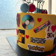 A full-blown 90s nostalgia cake! This design is covered in edible images of everything we loved from the 90s, like Cartoon Network, Pokémon, Poppins, and cassette tapes.