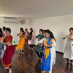 A snapshot from our Adavu meet, showing a group of dancers practicing their technique together. The space allows for clear sightlines for all participants in a workshop setting.
