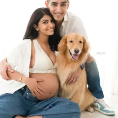 The whole family, fur baby included, comes together for this happy maternity portrait. It's a warm, genuine moment of love and excitement.