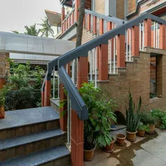 The entrance to this Bangalore home is designed as a gradual transition from the outside in. The staircase is flanked by greenery, and the use of exposed brick and stone creates a warm, earthy welcome.