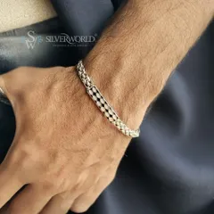 The diamond-cut centerplate bracelet, worn to show its sleek profile. It's a versatile piece that can be stacked with a watch or worn solo for a touch of refined style.