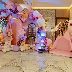 A magical fairy garden created for a birthday celebration. This elaborate setup includes a custom-built fairy house, a whimsical tent, glowing fairy wing props, and a pastel balloon arrangement to transport guests to an enchanted world.