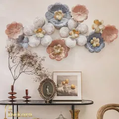 A modern floral wall sculpture with textured petals in soft pastel shades of pink and blue. This gentle and artistic piece can soften a corporate environment or serve as a beautiful home decor gift.