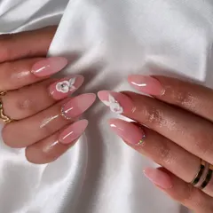 A delicate and feminine design. These almond-shaped nails feature a soft pink ombre base, accented with 3D white flowers and a sprinkle of rhinestones at the cuticle.