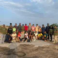 The entire group posing for a photo at sunrise on Minchukallu Betta. It's a shared experience of witnessing a new day begin.