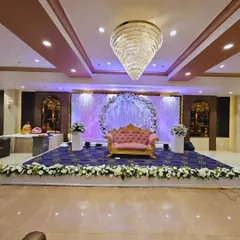 A wide-angle view of our ring ceremony stage setup in a banquet hall. This shows how the stage, with its floral arch and couple's sofa, becomes the central focus of the entire venue.