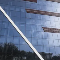 The modern glass facade of the Agni Devices building in Vikas Puri. We are proud to partner with forward thinking companies like this to implement green energy solutions.