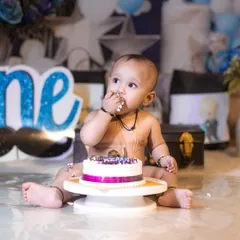 A candid moment of a baby boy tasting his birthday cake for the first time during his studio cake smash session.