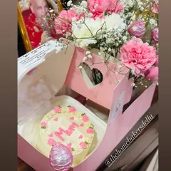 The perfect Mother's Day gift hamper. It features a custom 'Mum' bento cake in our signature pink box, paired with a beautiful bouquet of fresh carnations and glittery pink strawberry cake pops.