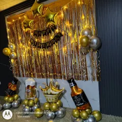 A fun birthday backdrop for an adult party. I used a gold foil curtain, fairy lights, and themed balloon stands like a beer mug and whiskey bottle.