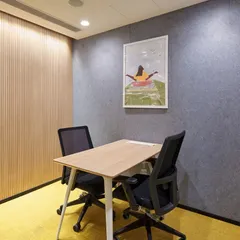 We create functional "huddle rooms" for private conversations or focused work. This space uses acoustic wall panels for soundproofing, a simple table setup, and a bold yellow carpet to add a touch of energy.