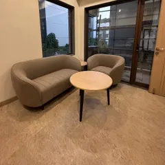 This seating arrangement, featuring a custom sofa and armchair, was designed for a client's specific space requirements, creating a comfortable and stylish conversation area.