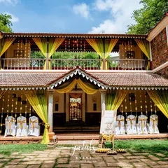 The entire facade of the heritage venue is draped in yellow and lime green fabrics, with marigold garlands hanging in the doorways, creating a festive and welcoming atmosphere for the Haldi ceremony.