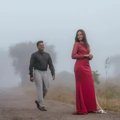 A romantic and atmospheric shot of a couple on a misty road. The fog adds a dreamy, mysterious quality to this mountain pre-wedding photo.