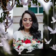 A beautiful portrait of the bride at her white-themed wedding celebration in Delhi, holding a bouquet of red and white roses.
