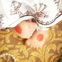 A close up on the tiny feet adorned with alta, a beautiful detail from our Navratri themed shoot. It's these small cultural touches that make a session truly special.