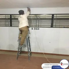 A technician carefully runs wiring for a security camera. We ensure all cabling is properly concealed and protected for a clean, professional finish and long-term durability.