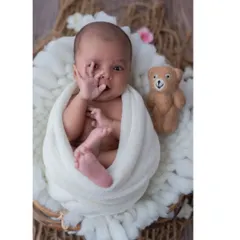 A moment of quiet curiosity. This baby, nestled in a basket with his teddy bear, brings his hand to his mouth in a classic newborn gesture. These are the authentic, unscripted moments I aim to capture.