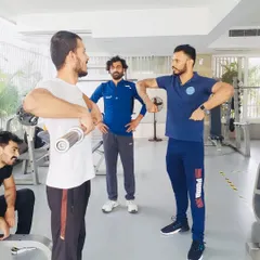 In my workshops, the focus is on interactive learning. Here, I'm demonstrating proper upright row mechanics to a group of aspiring CSCS coaches, ensuring they understand the "why" behind the movement, not just the "how."
