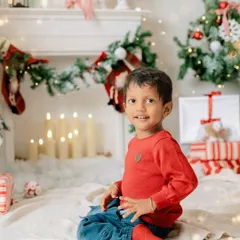 A quiet moment by the fireplace. This little one's sweet smile and the warm glow of the candles create a cozy and magical holiday atmosphere.