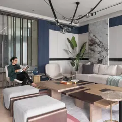 A comfortable seating arrangement in a modern living room, where we used a mix of neutral tones, a bold blue accent wall, and a statement marble panel. The design focuses on creating a welcoming space for relaxation and conversation.